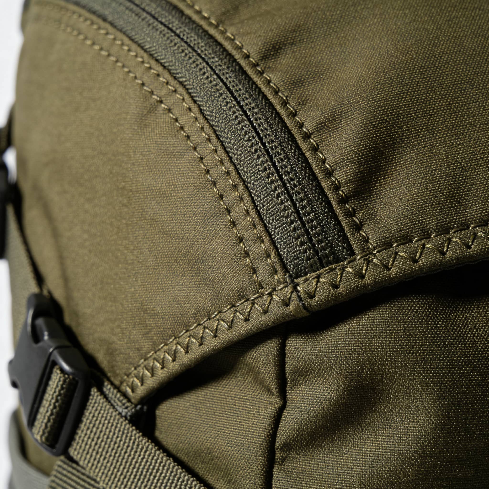 Tampilan cedhak konstruksi seam tas ransel sing nuduhake kualitas jahitan lan titik kegagalan potensial.