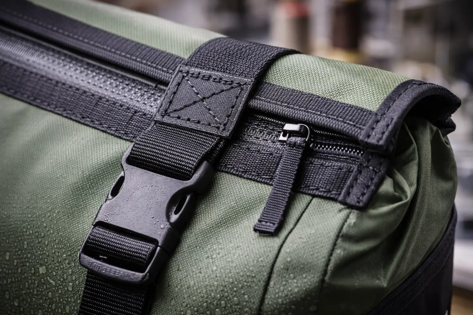 Macro view of pannier bag reinforcement with bartack and Box-X stitching, webbing anchors, and durable hardware